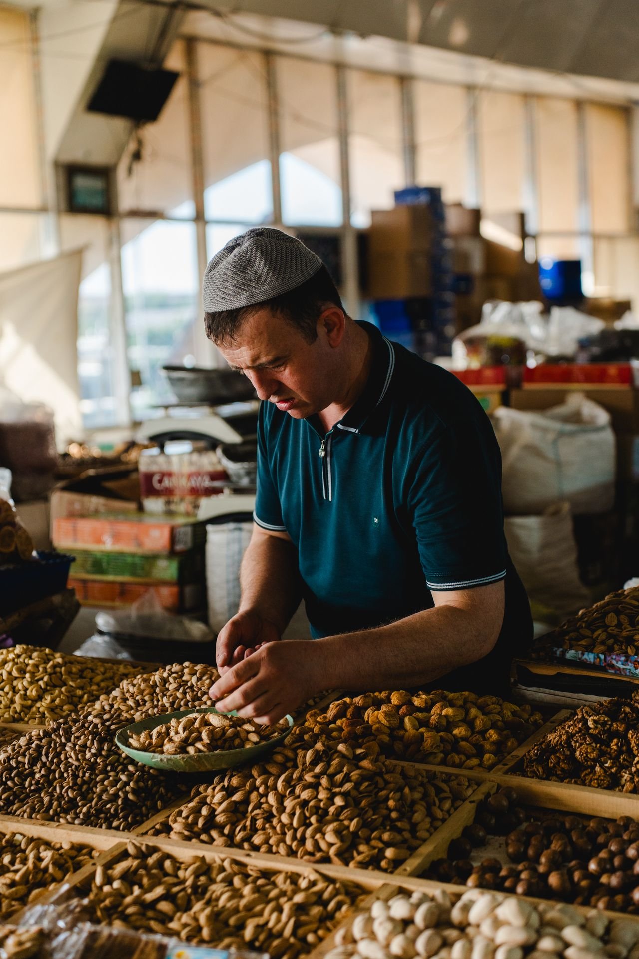 A merchant hand-selecting nuts at a market